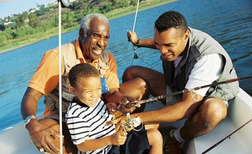Three generations of men fishing on a boat